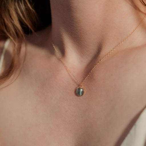 Necklace with a small pendant worn by a person